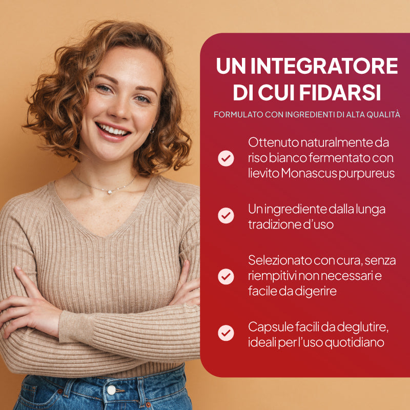 Una donna sorridente con i capelli ricci castano chiaro è in piedi su uno sfondo beige caldo; indossa un maglione a coste beige e jeans blu. Alla sua destra c’è un grande pannello informativo rosso con un testo in italiano scritto in bianco su un integratore probiotico, che include elenchi puntati e segni di spunta.